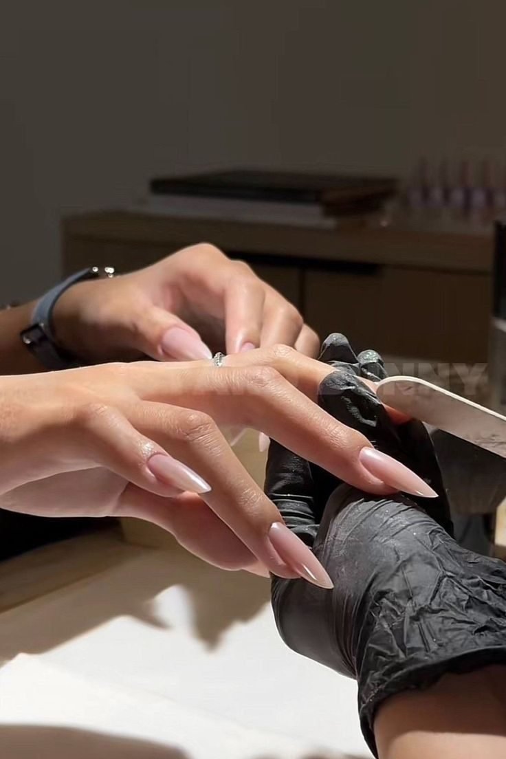 Maniküre: Nagelfeile und schwarze Handschuhe bei der Handpflege