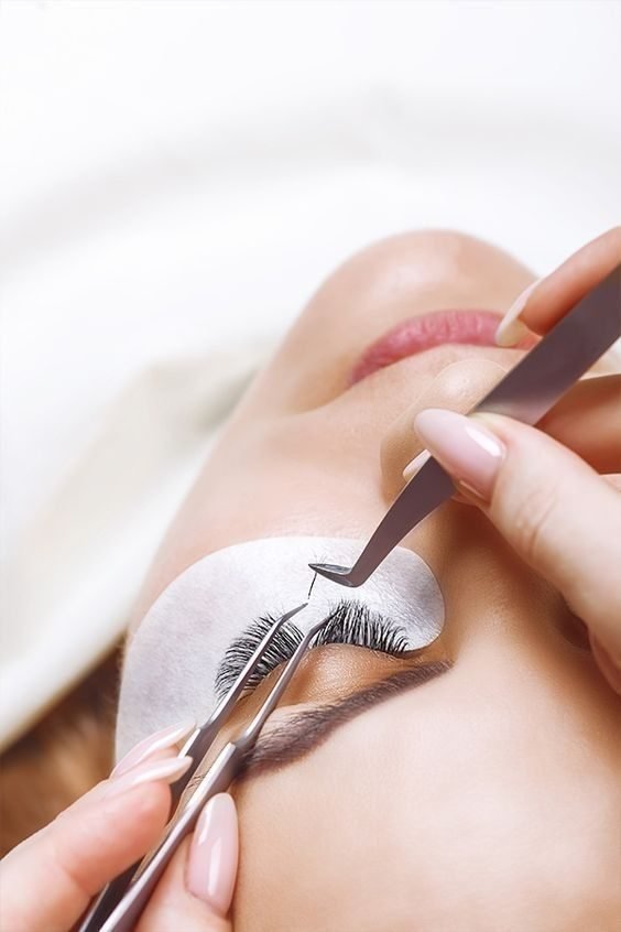 Wimpernextensions werden mit einer Pinzette angebracht